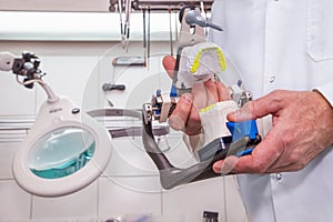 DentistÃ¢â¬â¢ s hands with model in a dental prothetic laboratory photo